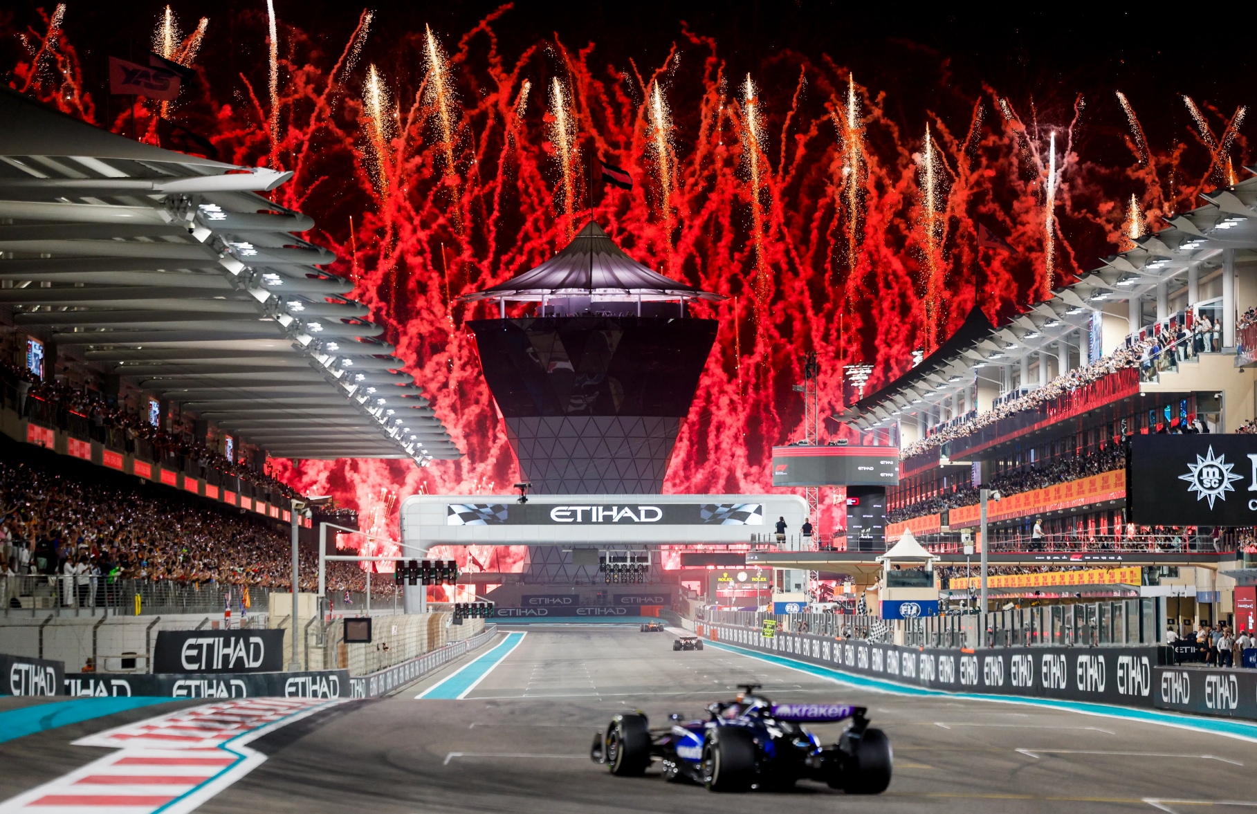 Formula 1 cars racing at sunset on Yas Marina Circuit 2025